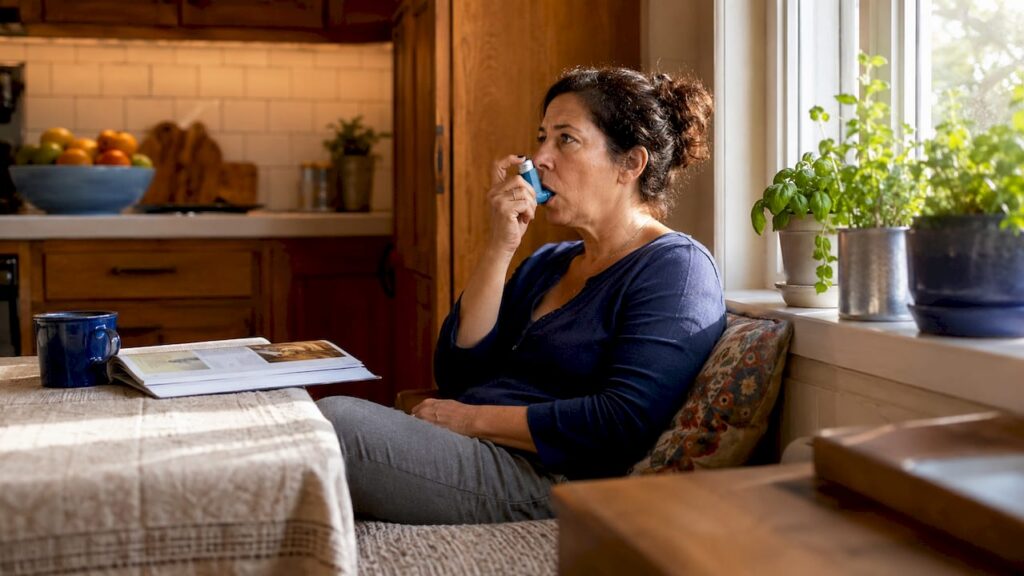 Woman using inhaler in living room