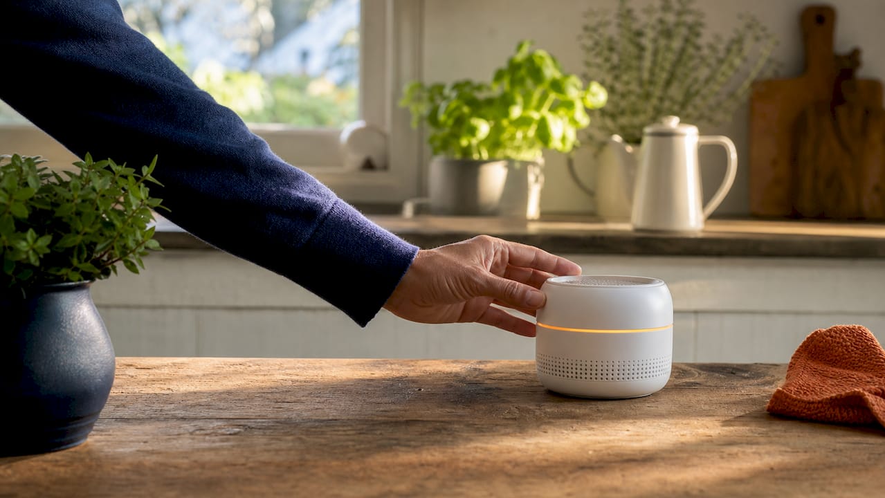 Hand adjusting indoor air quality monitor on windowsill